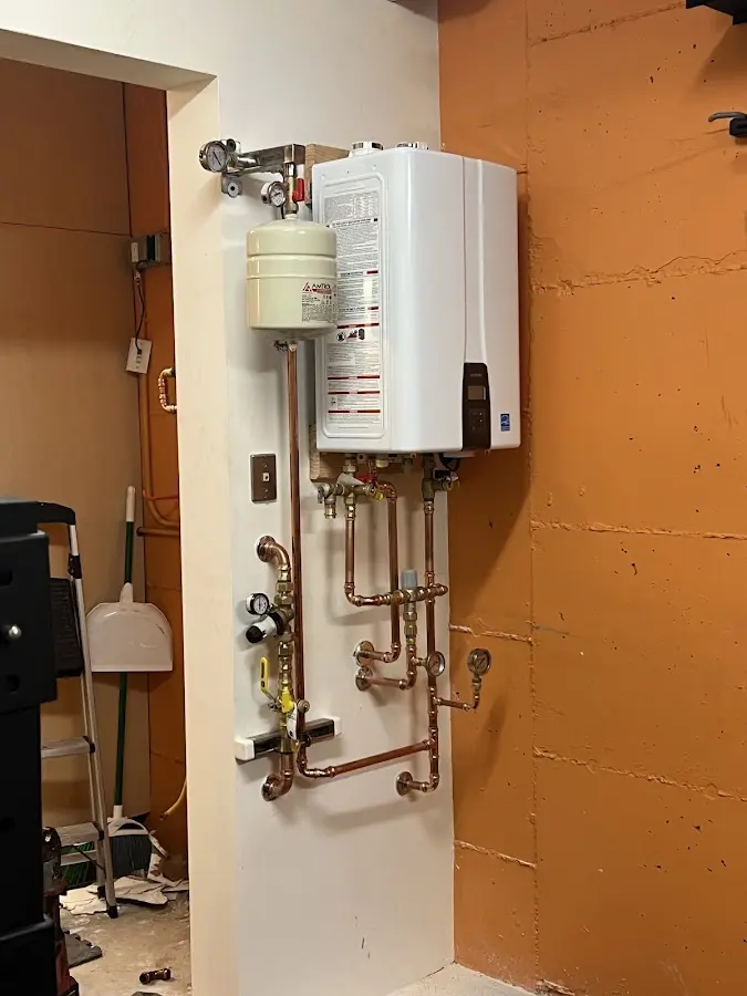 Plumbing technician inspecting water heater connections in Fresno